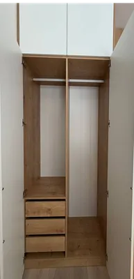 Функциональное наполнение шкафа для одежды: деревянные выдвижные ящики, полки и штанги для вешалок в современной детской.