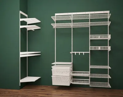 Белая металлическая сетчатая гардеробная система с корзинами и полками на фоне темно-зеленой стены и коричневого деревянного пола.