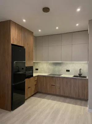 Угловой кухонный гарнитур до потолка с деревянными фасадами, серыми антресолями и скрытым профилем Gola для открывания без ручек.